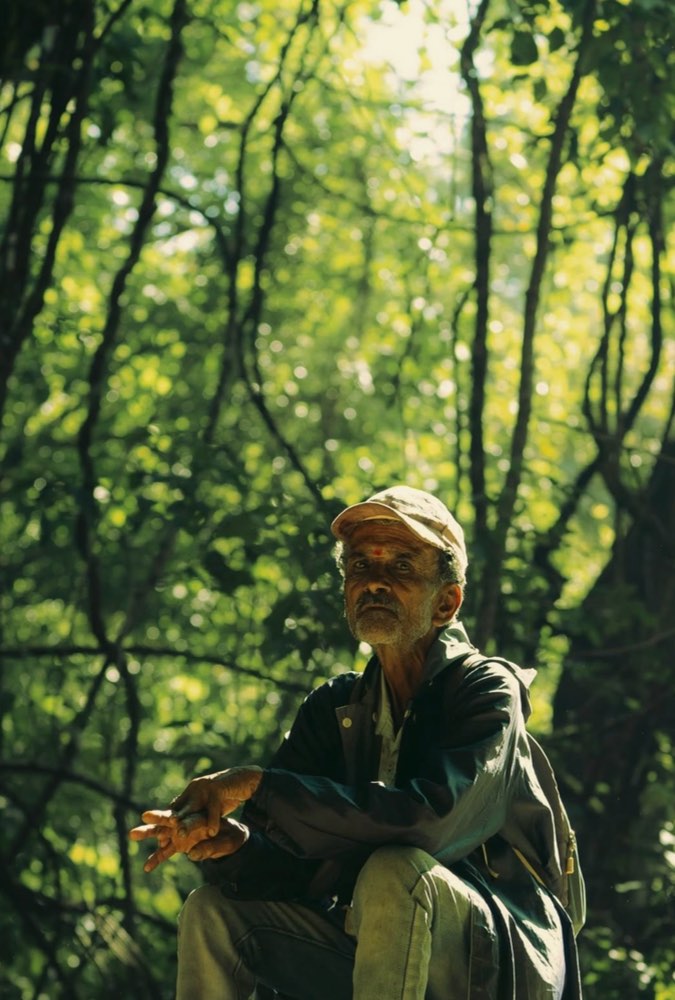 A local trek guide resting in the forest
